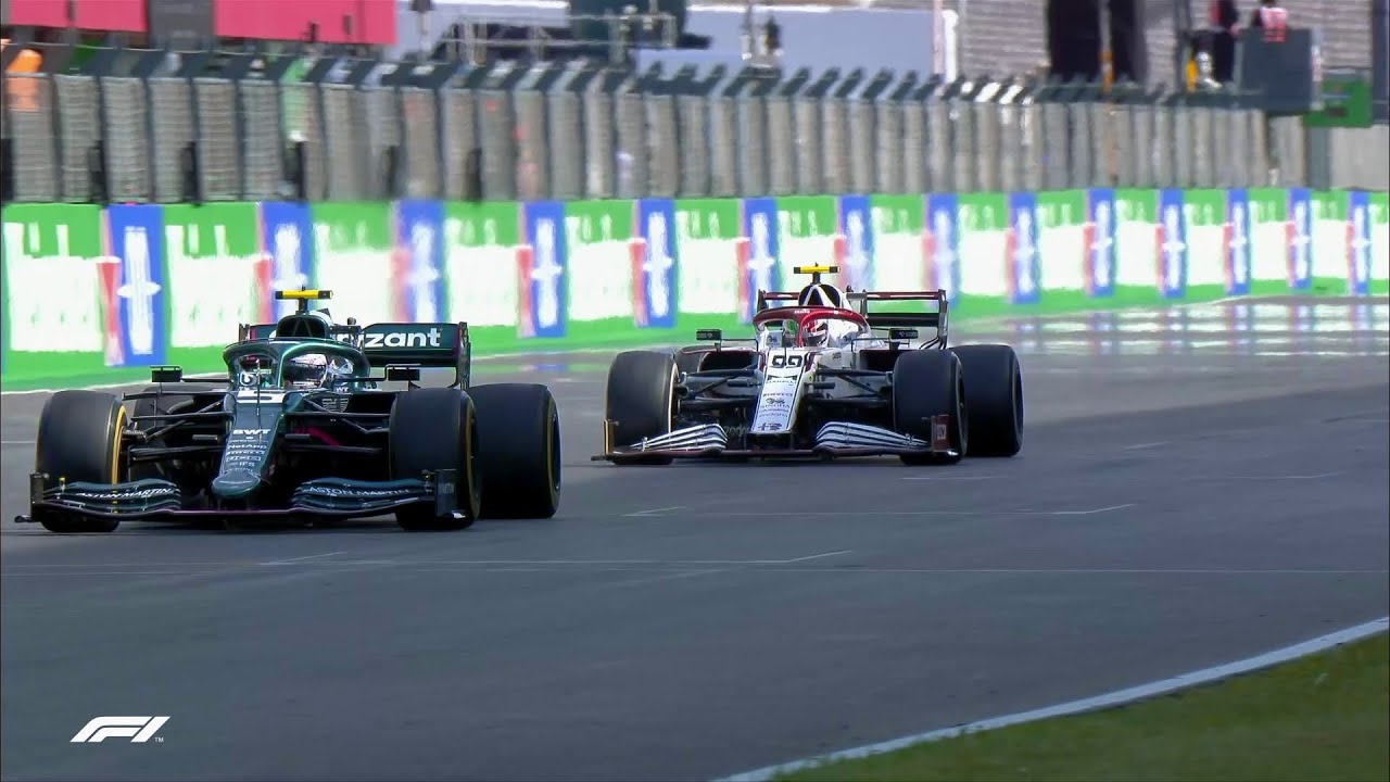 Two Formula 1 cars racing side by side on a track, with the Aston Martin car on the left and the Alfa Romeo car on the right.