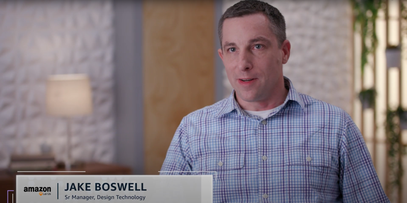A person sitting in a modern office environment, identified as a Senior Manager in Design Technology at Amazon Lab126, is being interviewed. The background includes textured walls, a lamp, and plants, creating a professional atmosphere.