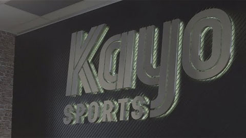 "Kayo Sports logo on a dark textured wall."