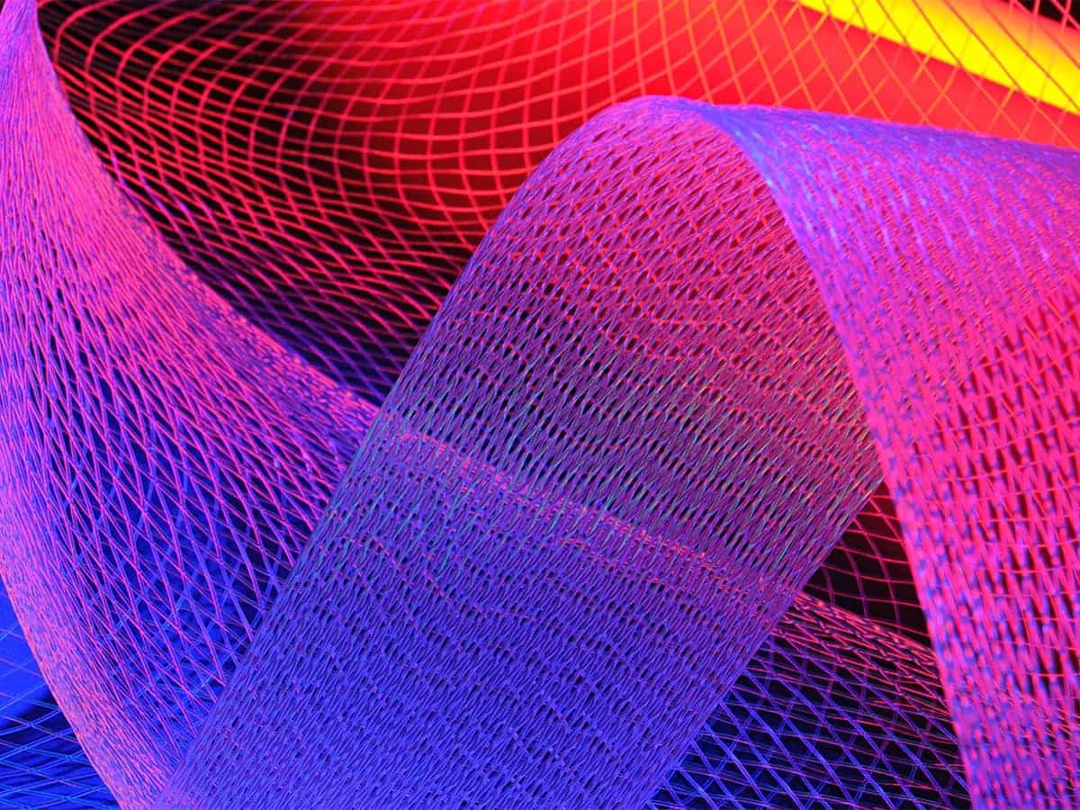 An abstract image featuring a mesh or net-like pattern in vivid pink, purple, blue, and red hues, symbolizing digital connectivity or networking.
