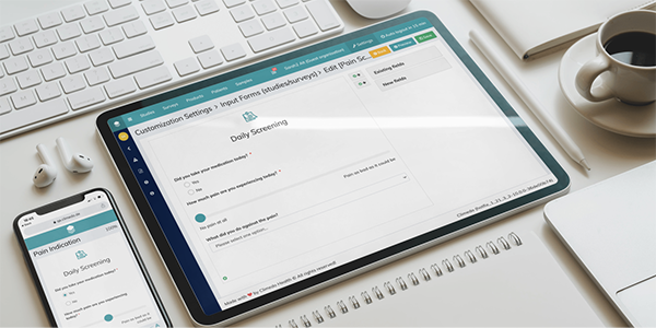 A tablet and smartphone displaying a 'Daily Screening' input form on a clean office desk setup with a keyboard, notebook, pen, earphones, and a coffee cup. The scene represents a digital compliance or healthcare screening workflow in a modern workspace.