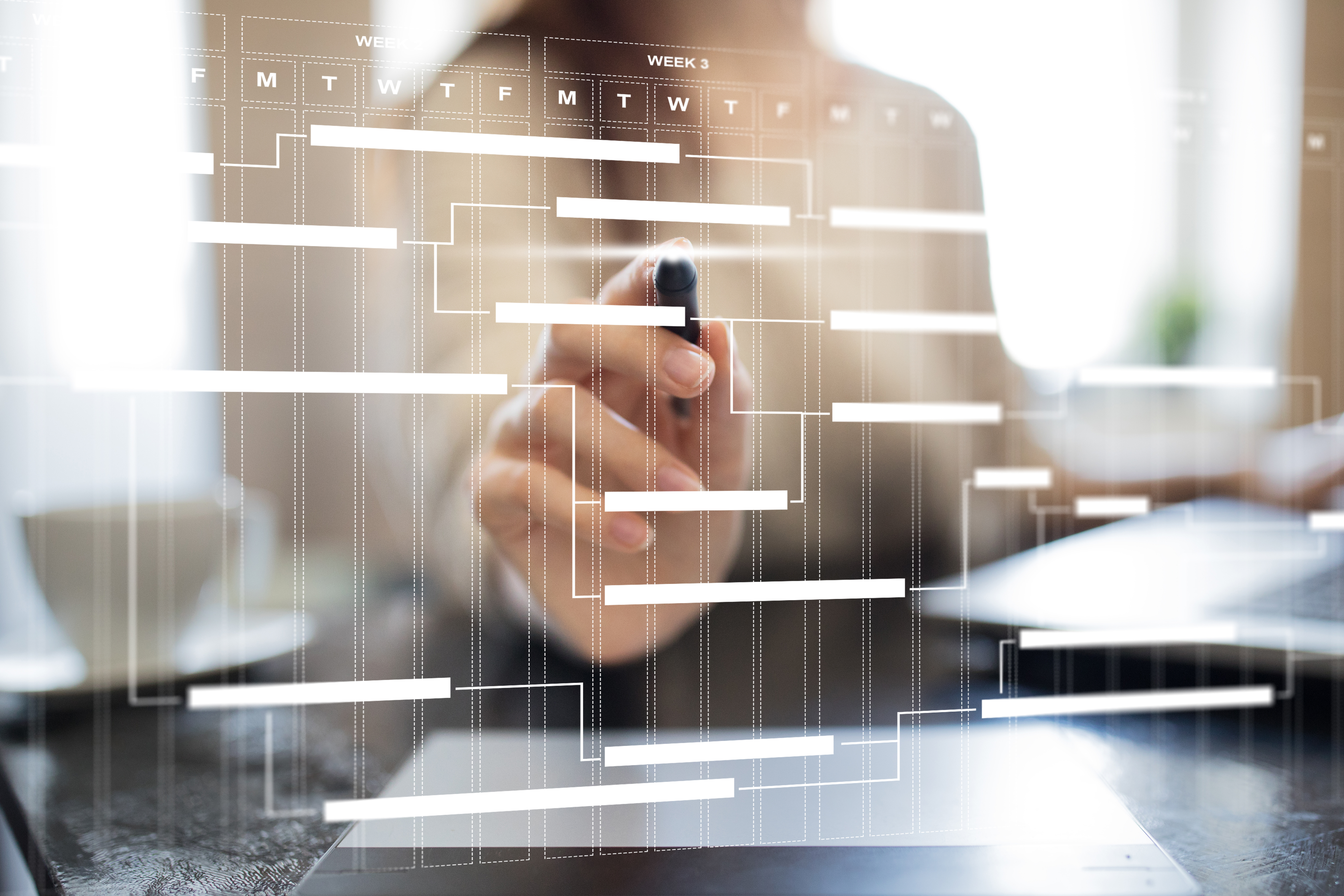 A person marking or interacting with a transparent workflow or Gantt chart on a screen, symbolizing project management, planning, or workflow visualization.