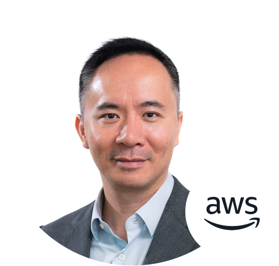 Professional headshot photo of a male individual in a suit with the AWS logo in the corner, on a white background.