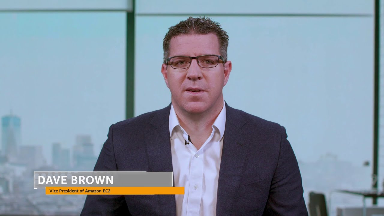 YouTube thumbnail featuring Dave Brown, Vice President of Amazon EC2, in a suit and glasses, seated in front of a windowed office background.