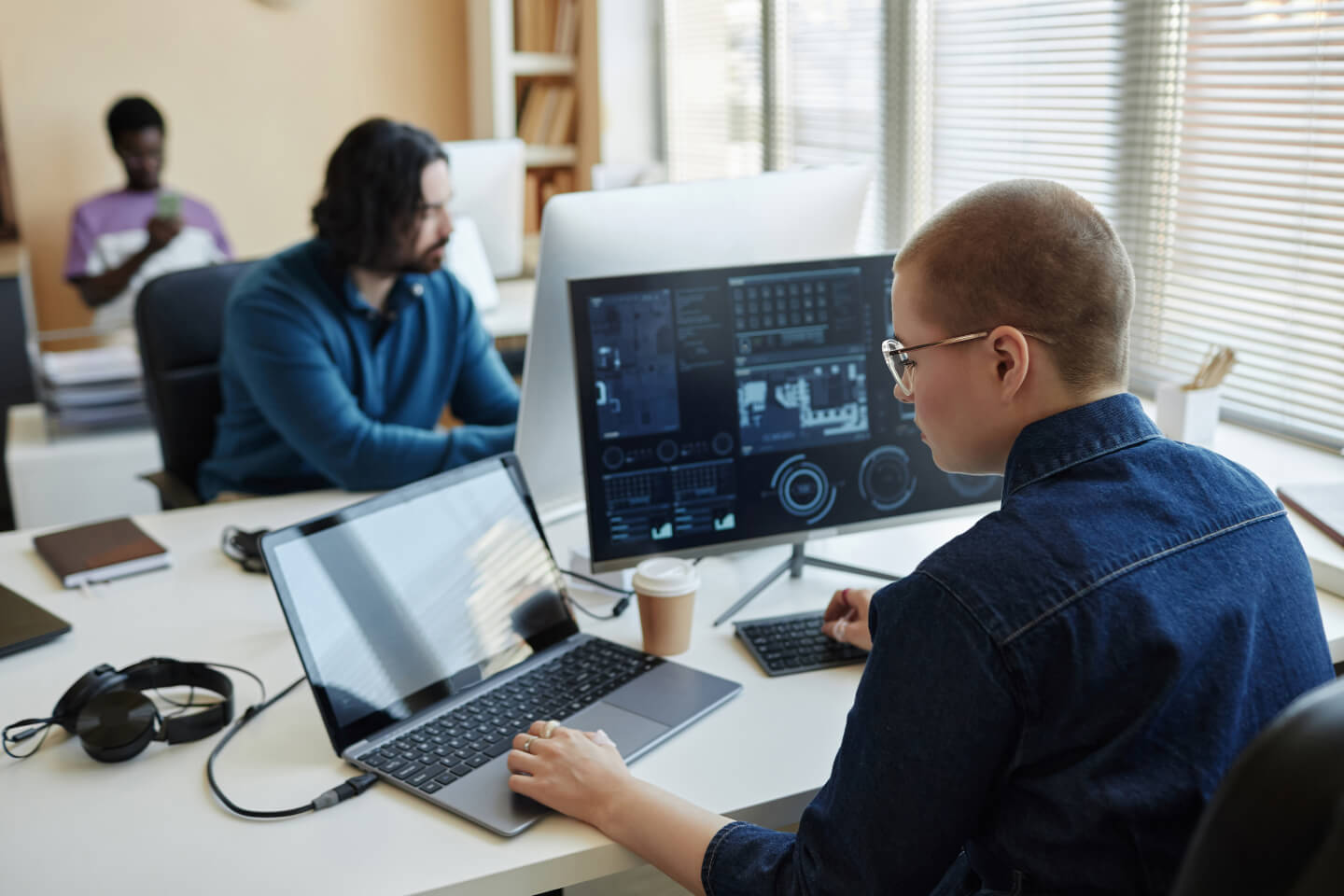 Business decision maker at desk reviewing data in a spreadsheet across multiple screens