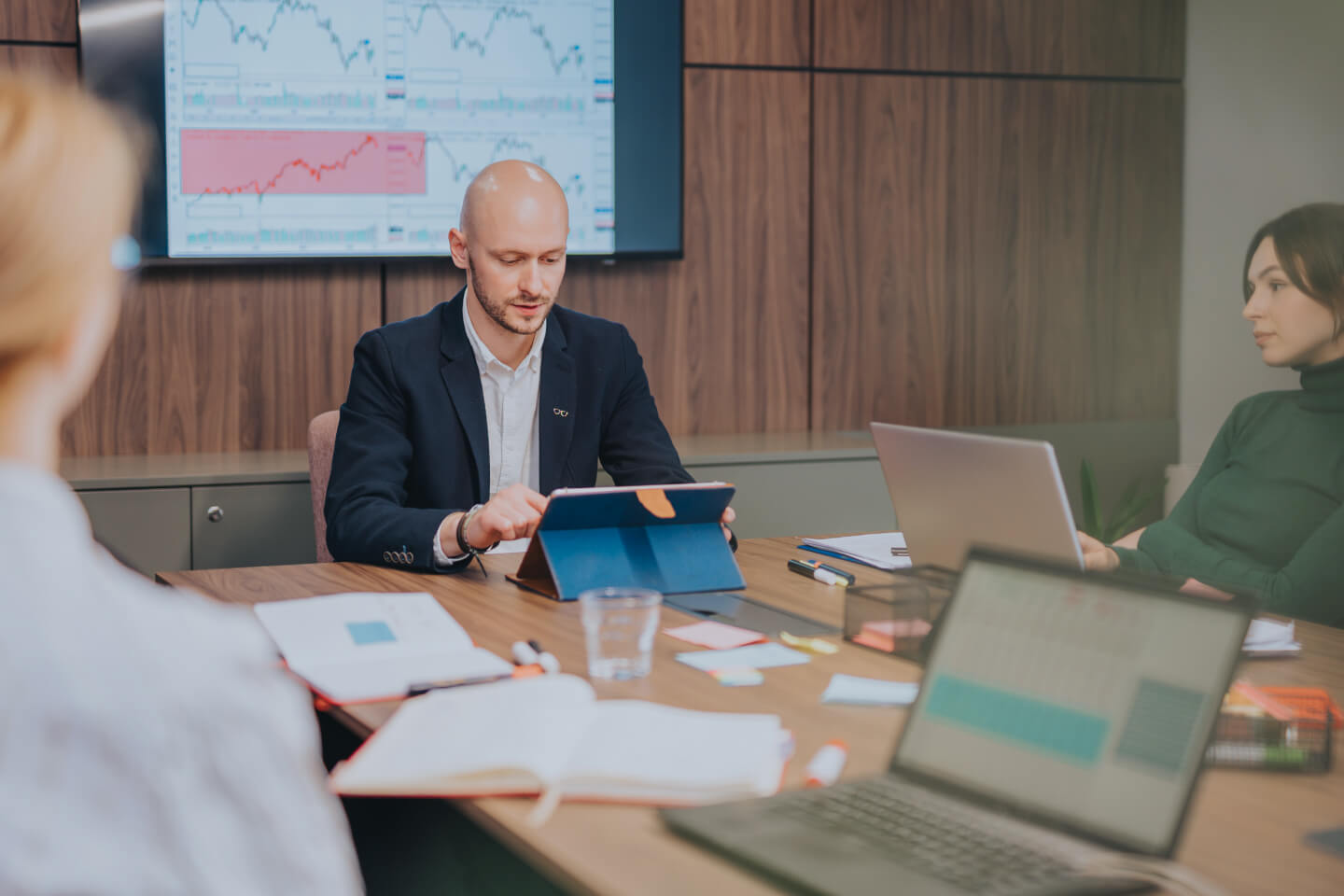 Data analysts sat around meeting table, reviewing and forecasting data