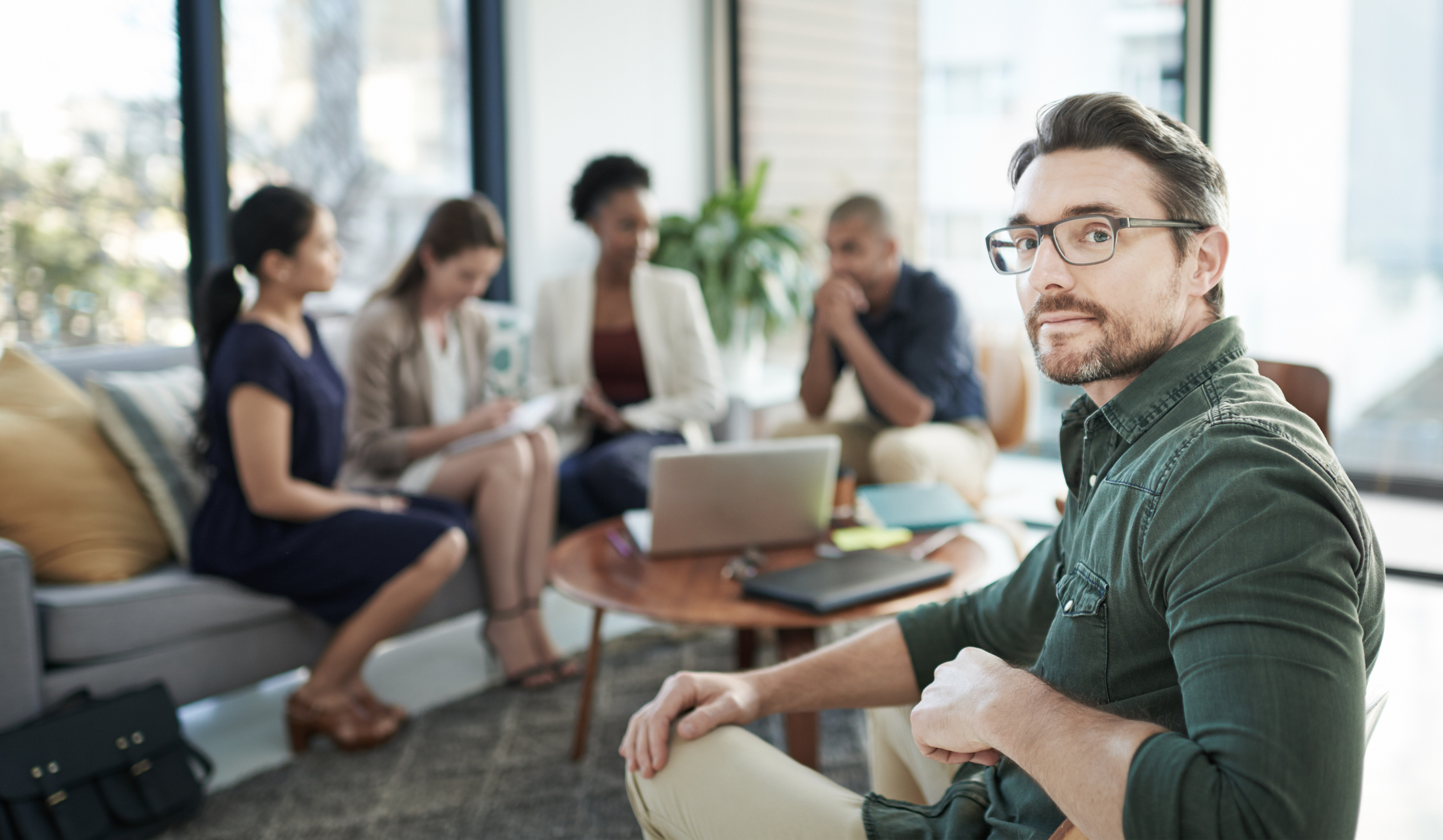 Portrait of a businessman with his team having a meeting in the background