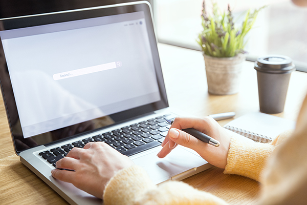 Close up of person using a search engine on a laptop