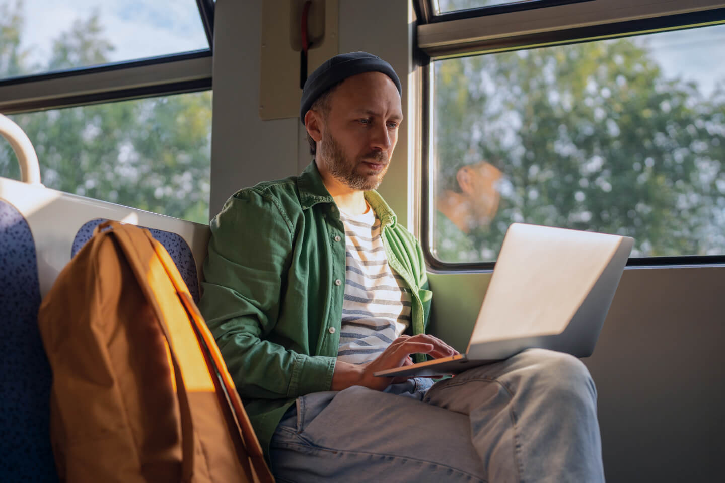 Remote worker using laptop whilst sat on a train