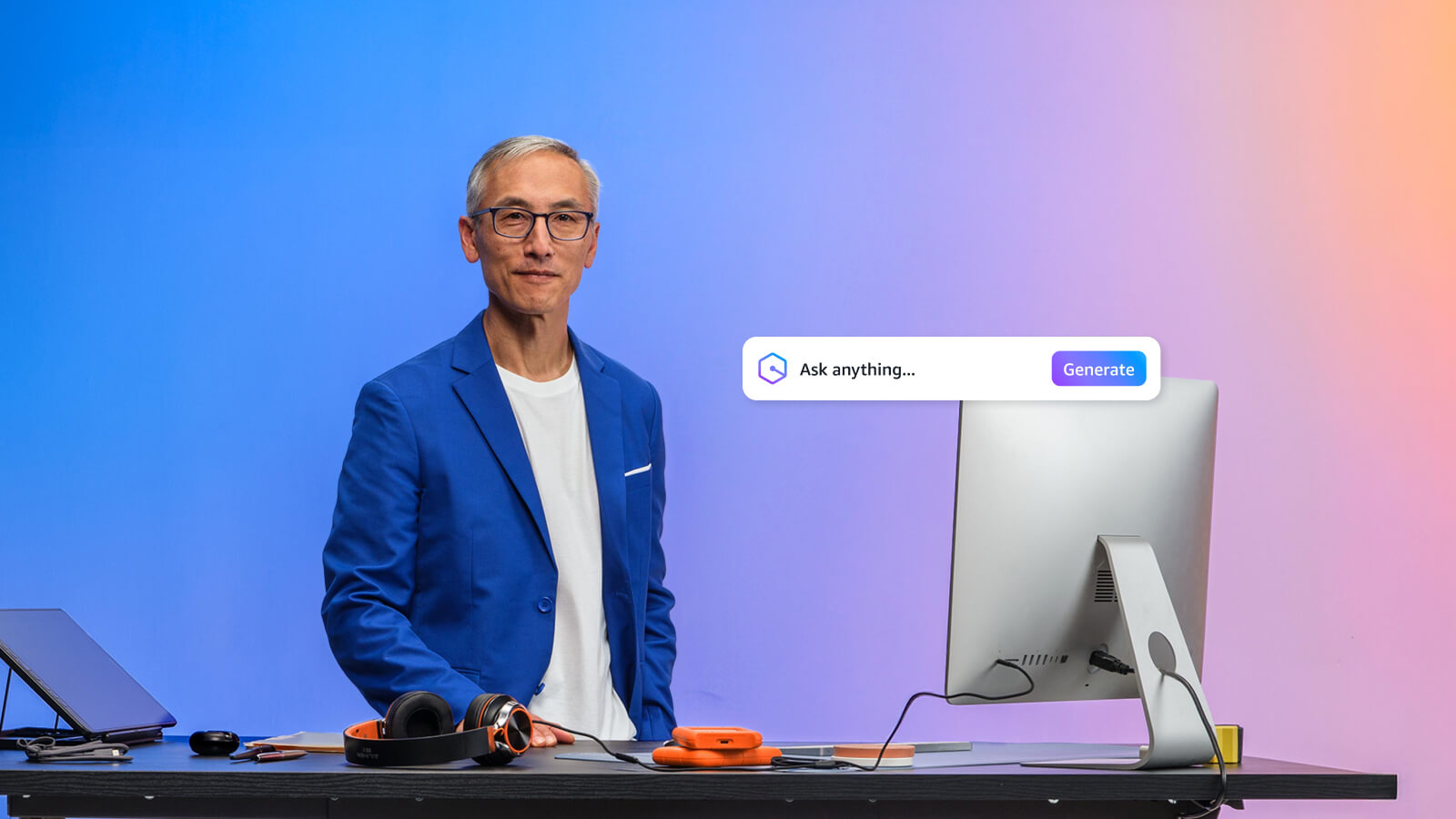 Asian man standing at desk asking questions to Amazon Q