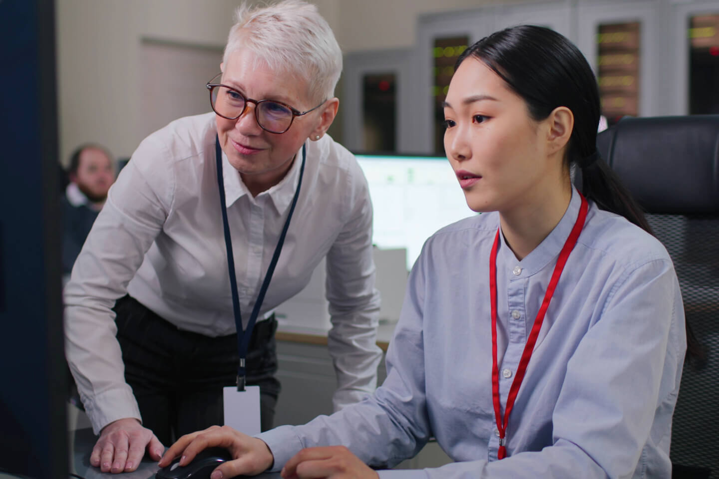 Technical decision makers wearing lanyards and looking at computer