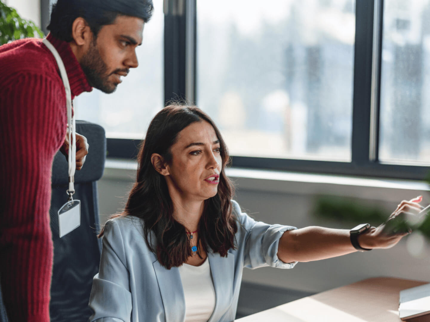 Technical experts in discussion, pointing at computer screen