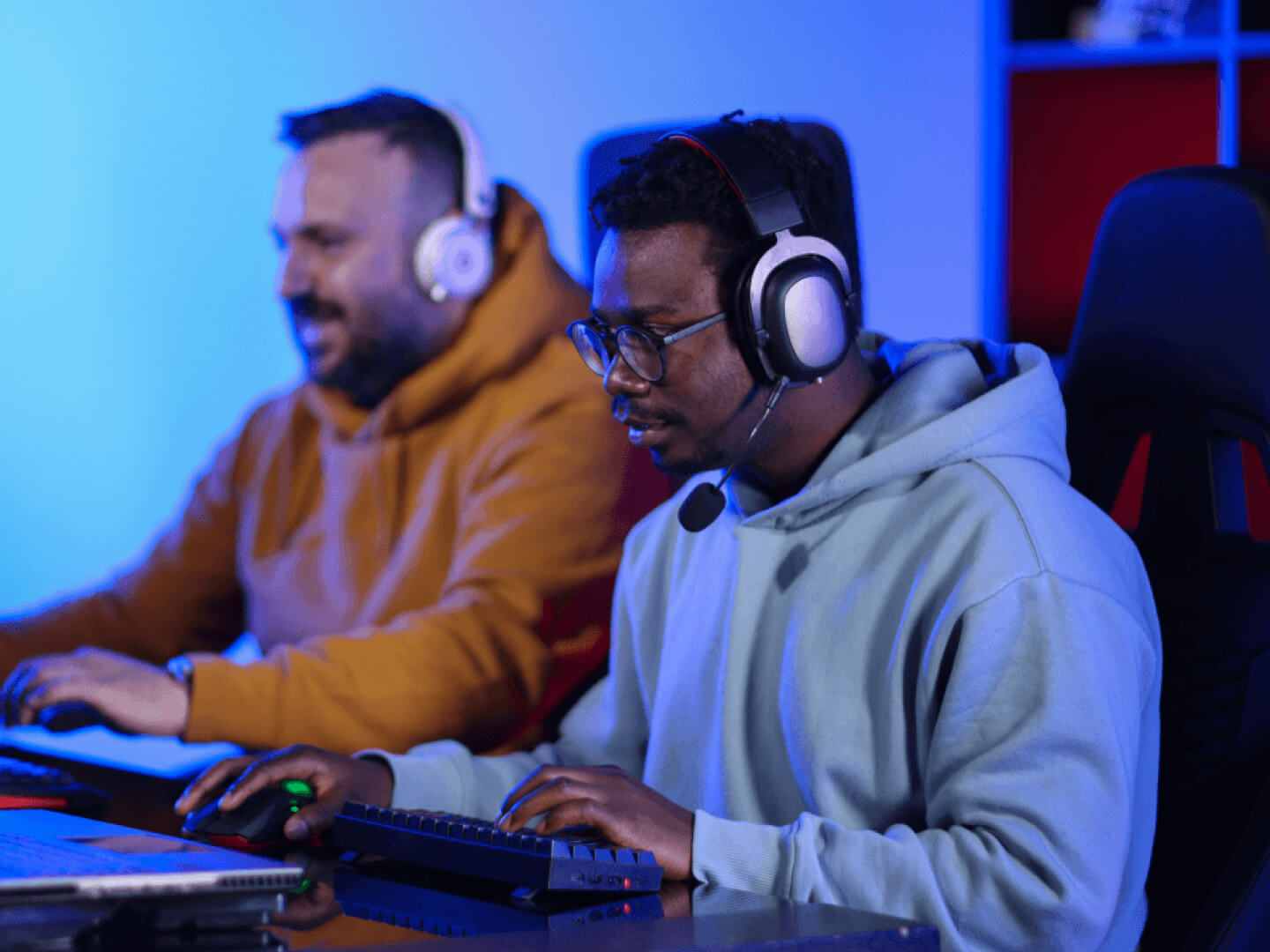 Technical experts wearing headphones working in blue light office