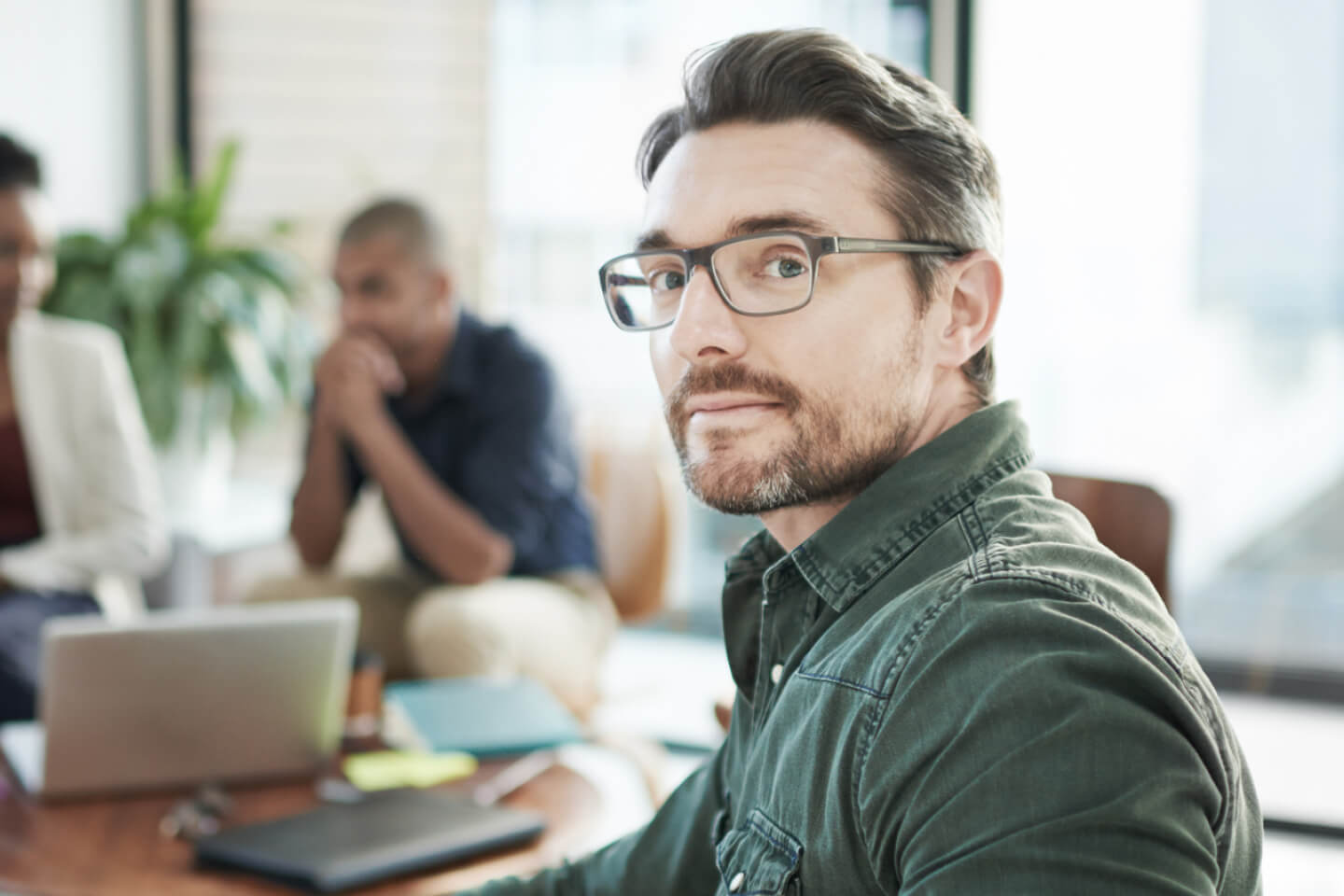 Man in glasses staring while people work