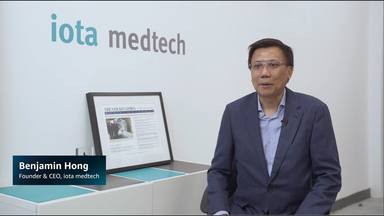 Interview with Benjamin Hong, Founder and CEO of iota medtech, seated in a modern office with the iota medtech logo on the wall.