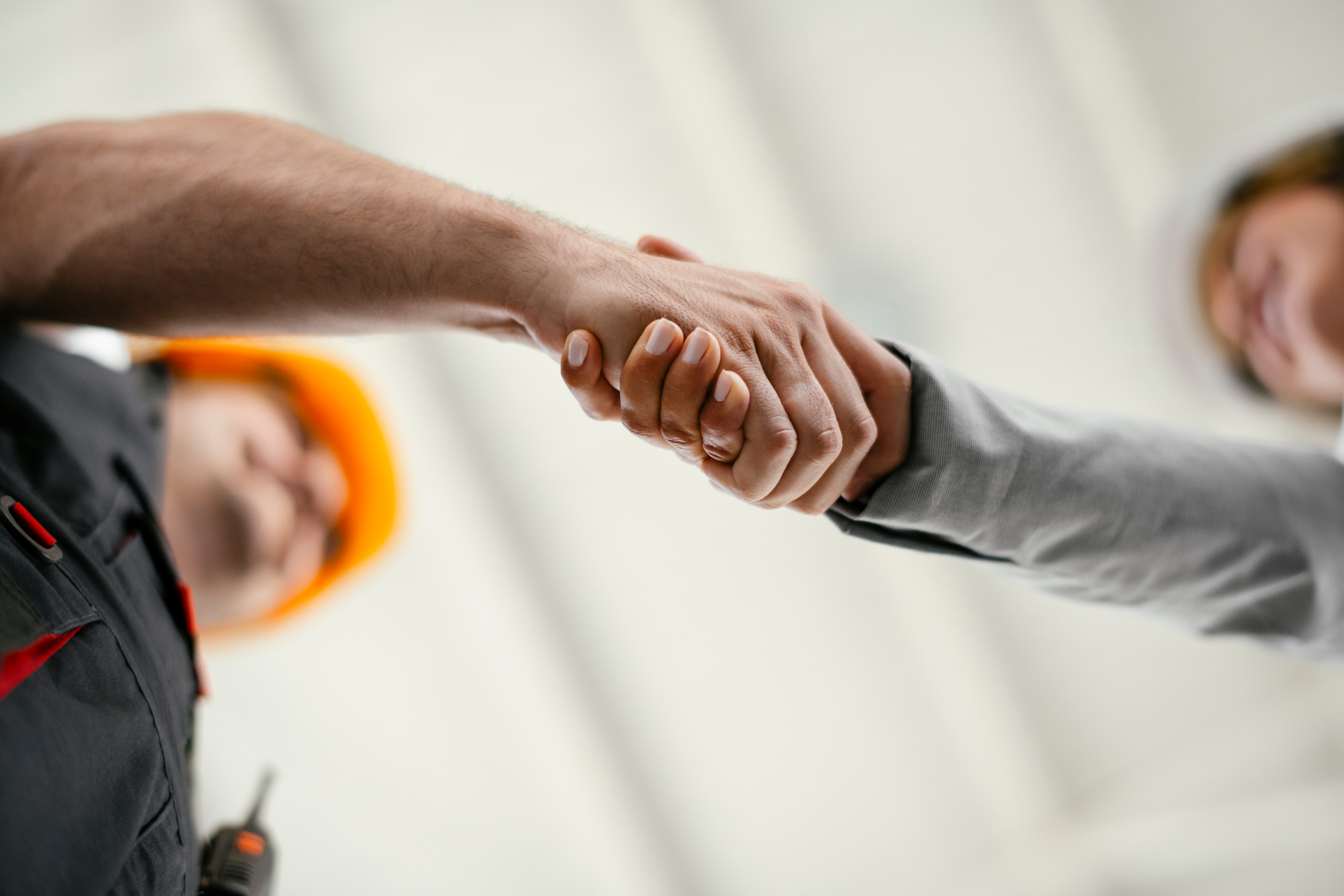 Close up of factory worker giving handshake to a engineer. Business handshake.; Shutterstock ID 1607487217; purchase_order: MRG case study; job: AWS; client: gcrp