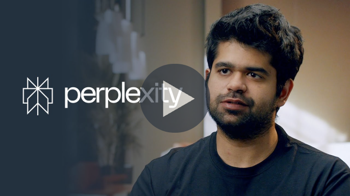 Alt-text: "Perplexity logo displayed on a dark overlay with a blurred background featuring indoor lighting and decor."