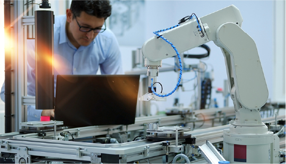 A robotic arm working on an industrial assembly line with machinery in the background.