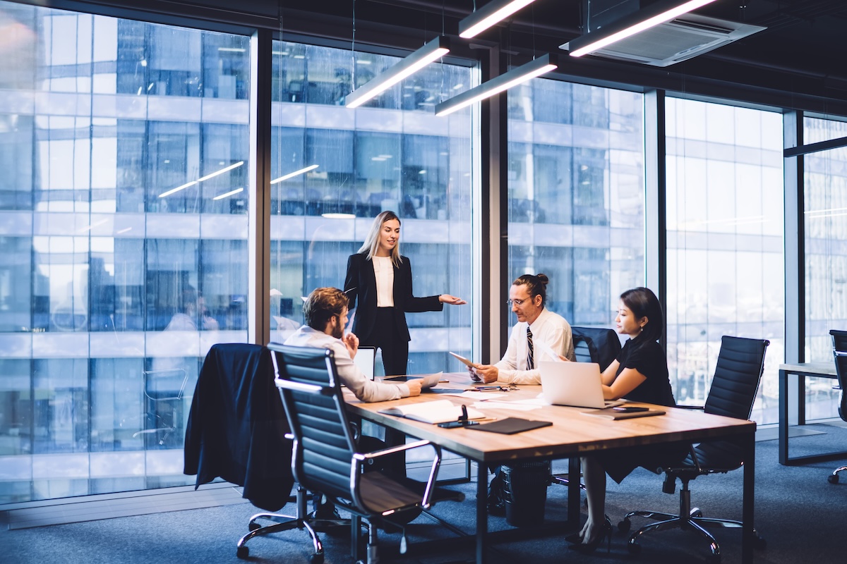 Professional financial experts collaborating during brainstorming meeting listening information from clever female director, businesswoman providing information to corporate workers of company