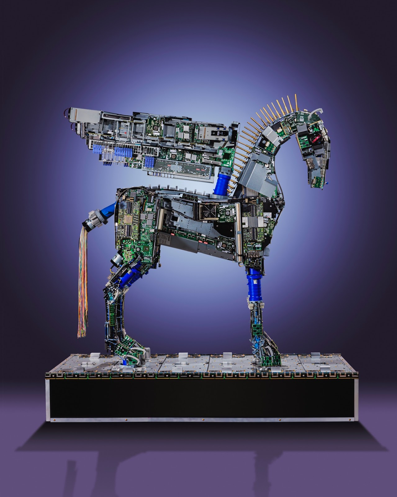 A sculpture of a horse made from computer circuit boards and electronic components, set against a gradient purple background.