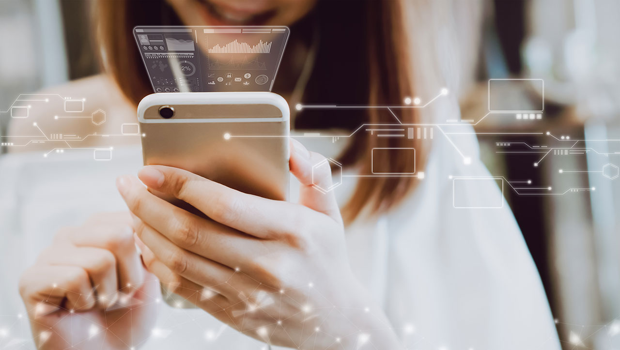 A woman holds a smartphone with futuristic digital data and analytics graphics overlaid, representing mobile technology, data visualization, and innovation.