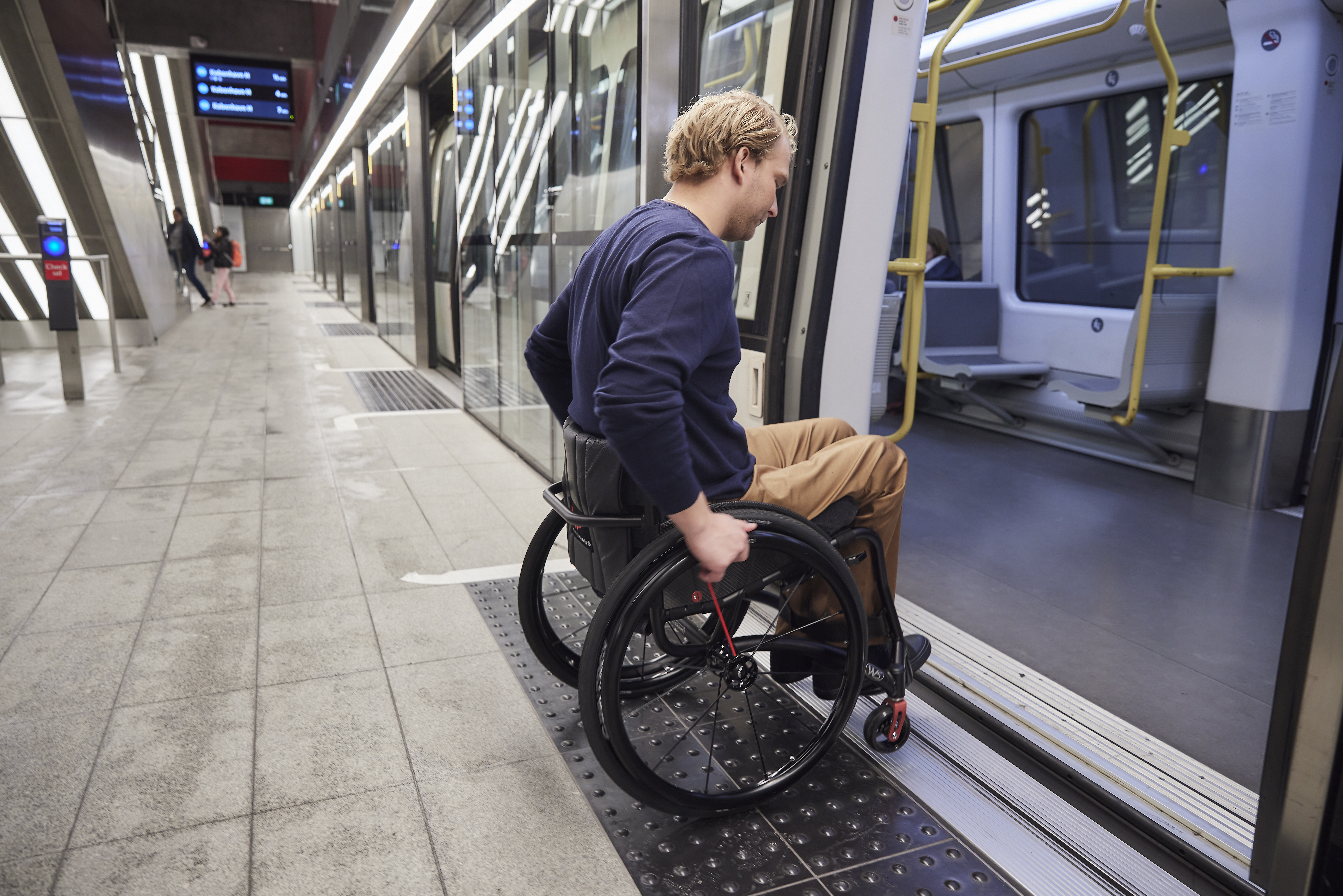 man on wheelchair riding into the subway