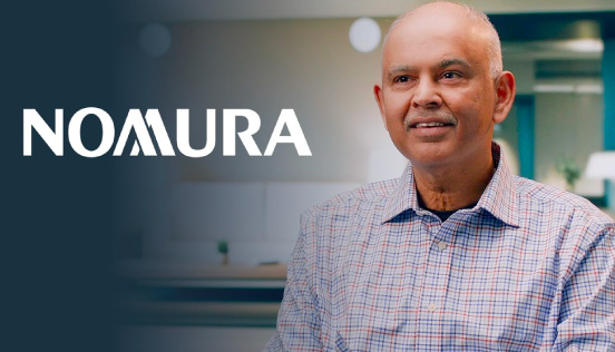The Nomura logo displayed on a dark background next to a person wearing a checkered shirt in an office setting.