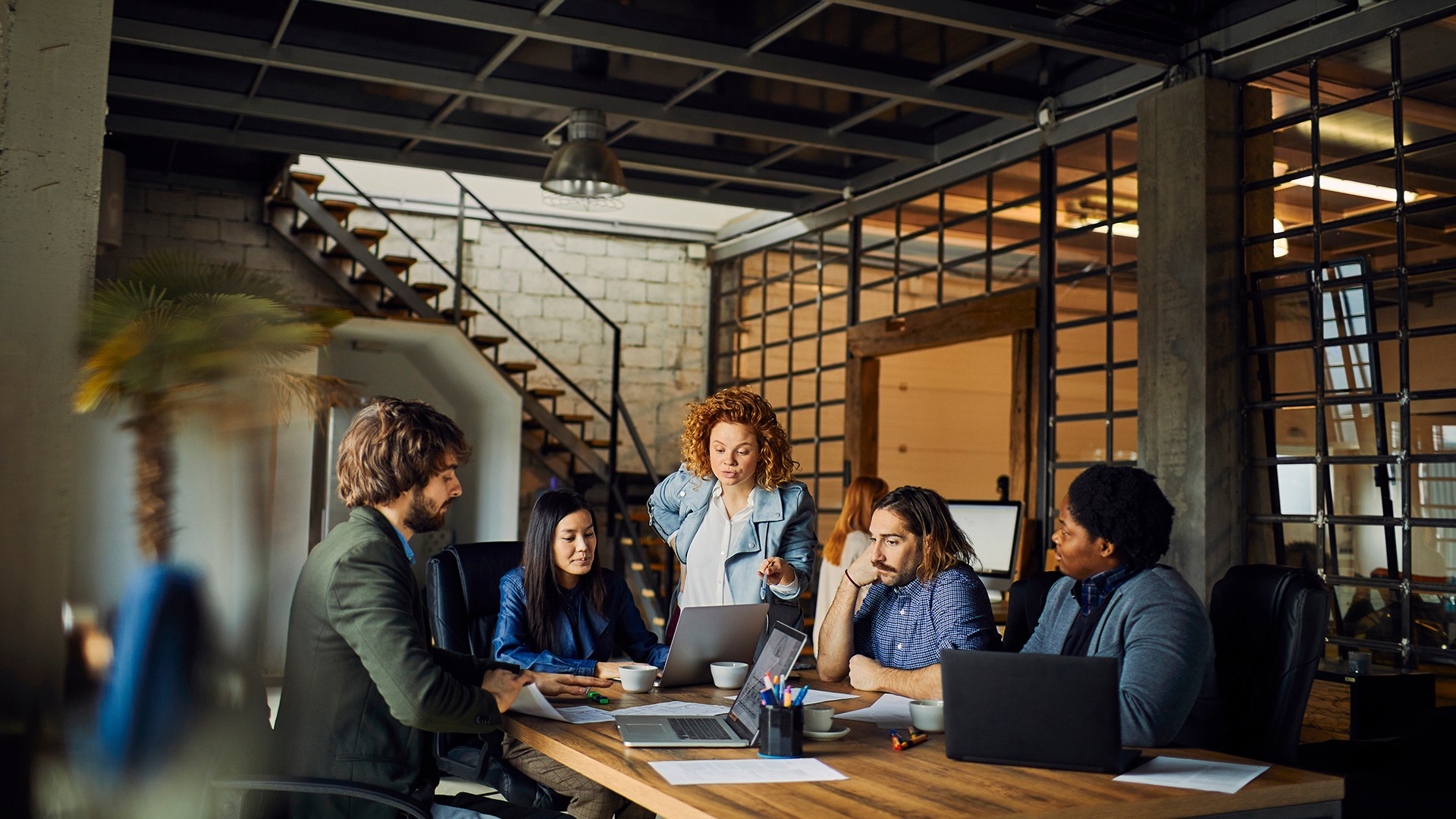 Diverse startup team collaborating around a table in a modern office