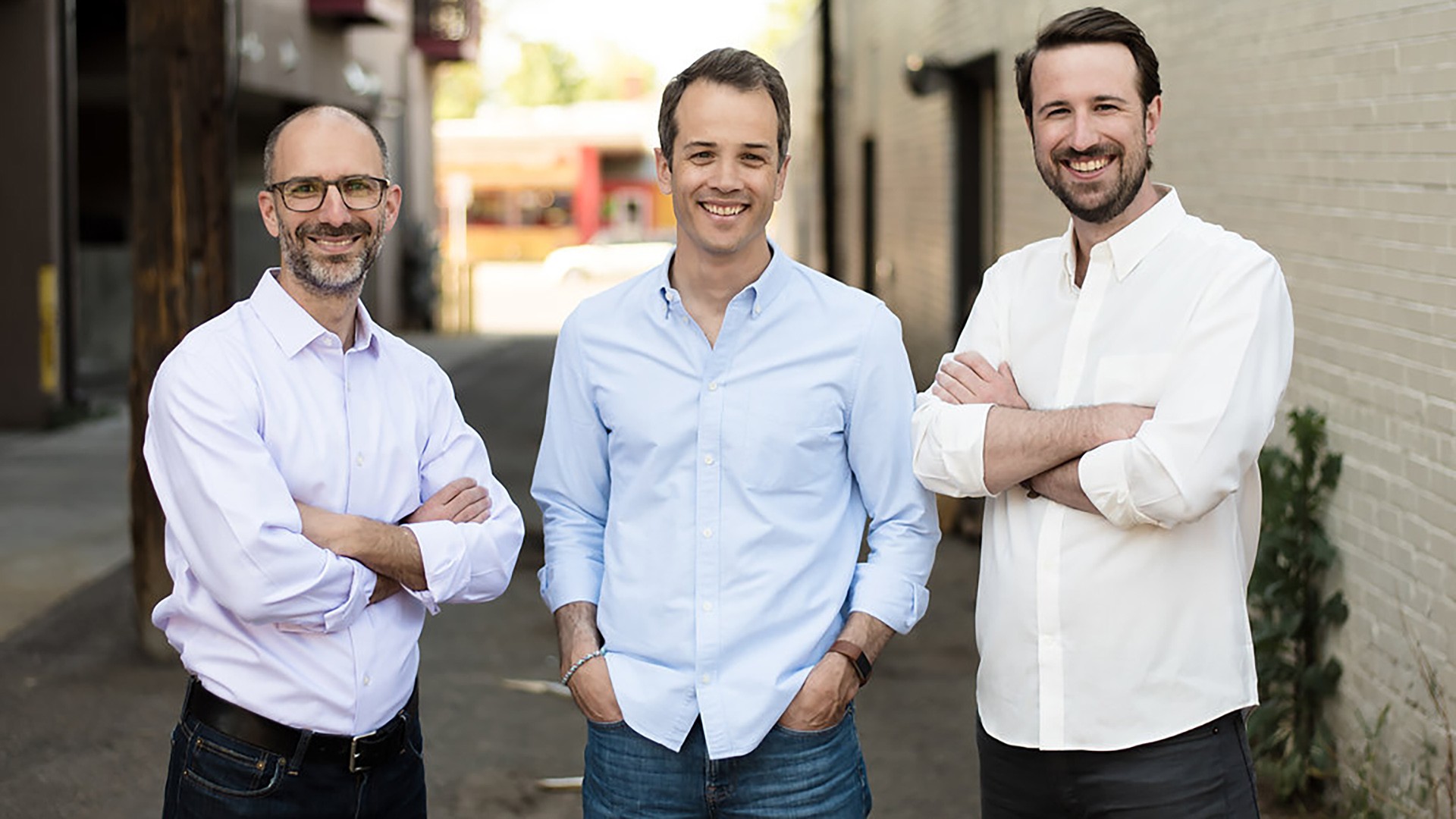 Three Parsyl team members smiling together at a company happy hour in Denver