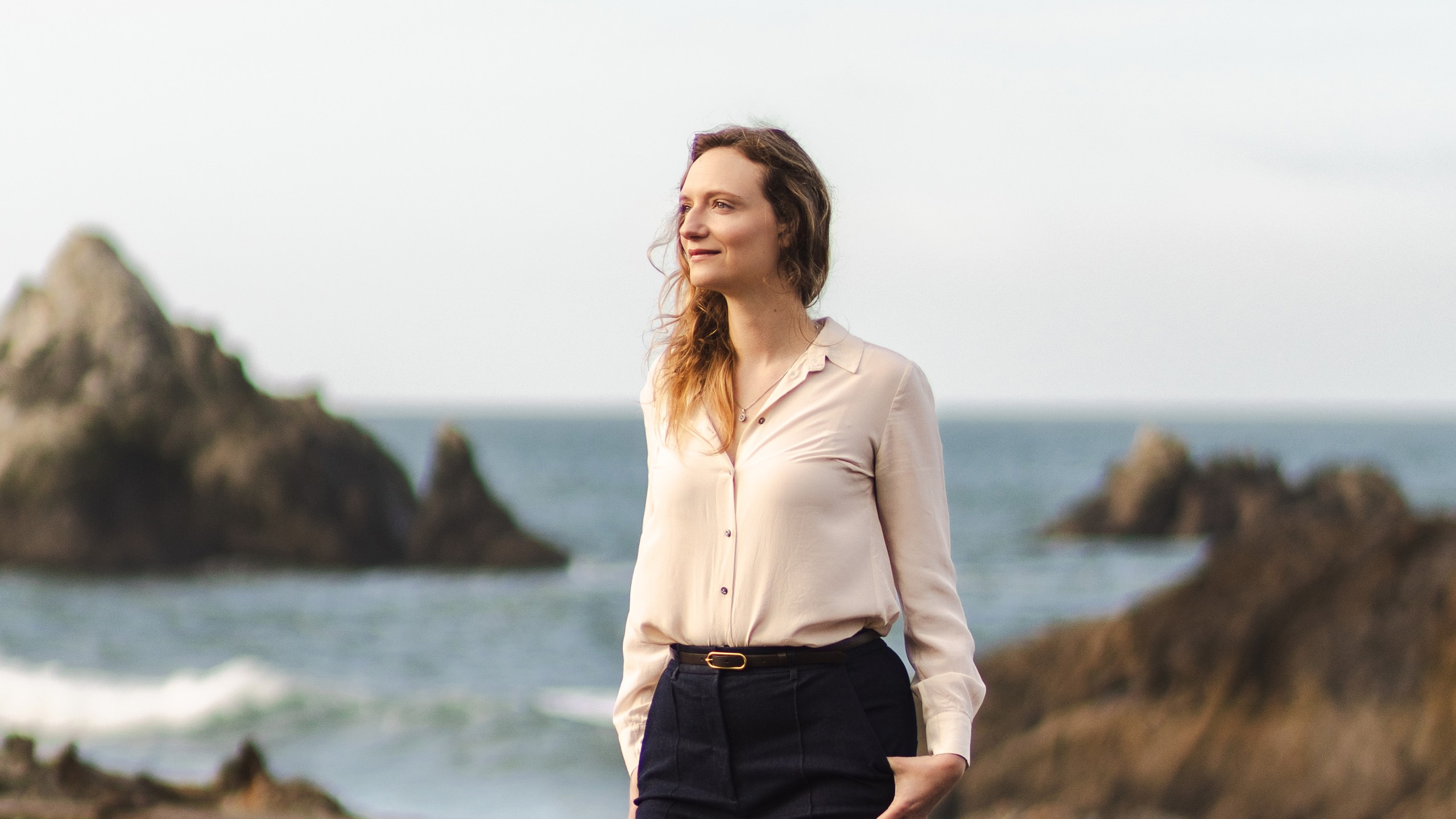Pathway CEO standing by coastal cliffs, illustrating the Pathway BDH post-transformer AI article for enterprise AI on AWS.