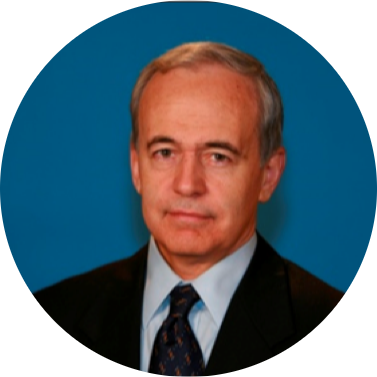 Circular portrait image of an older man with gray hair, wearing a suit and tie, against a blue background.
