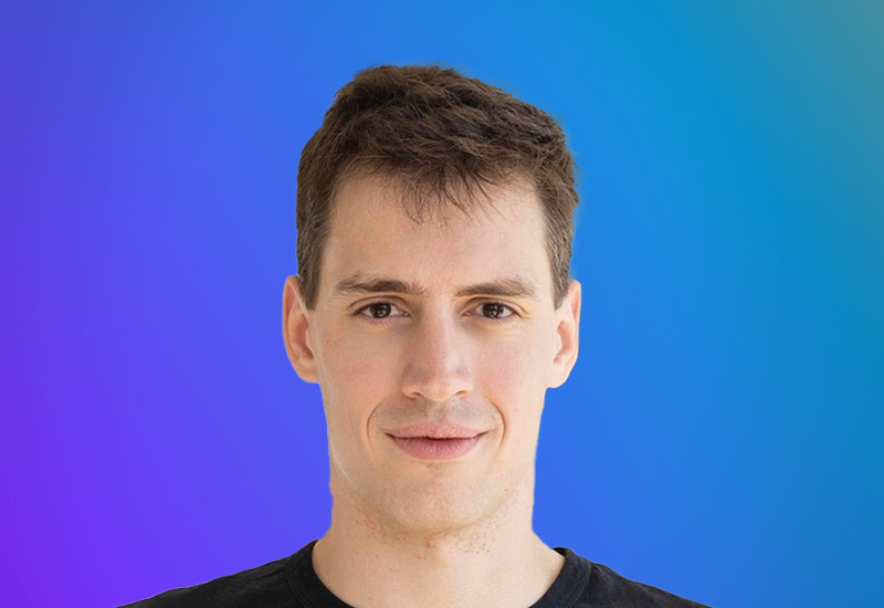 Headshot of a young man with short brown hair in front of a blue and purple gradient background.