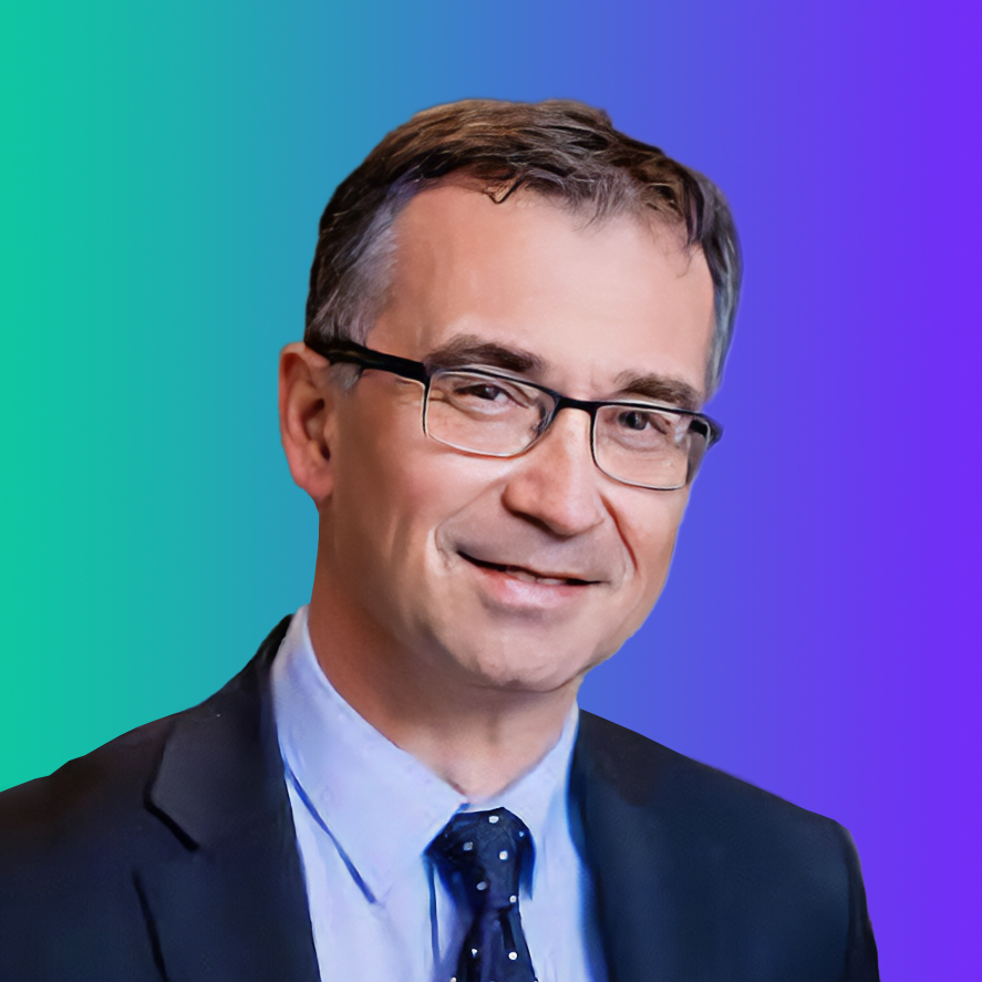 Portrait of a person in a suit and glasses posed in front of a blue to green gradient background.