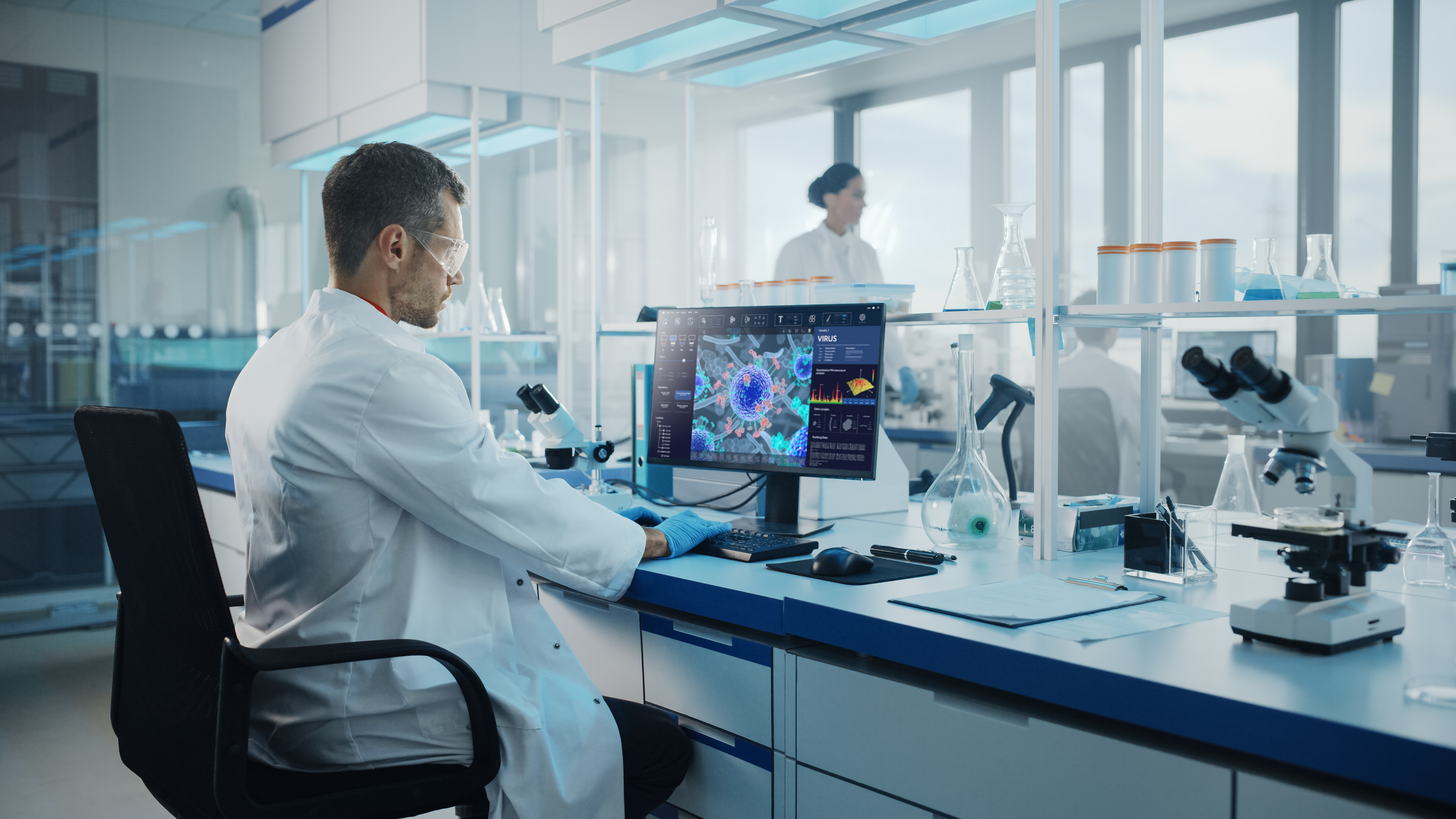 Advanced Medical Science Laboratory: Medical Scientist Working on Personal Computer with Screen Showing Virus Analysis Software User Interface. Scientists Developing Vaccine, Drugs and Antibiotics.; Shutterstock ID 1912524385; purchase_order: OneBio case study; job: AWS; client: case study; other: EMEA