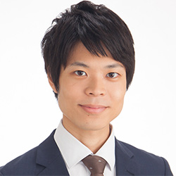 Professional headshot of a young man in a business suit with a tie, posing against a plain white background.