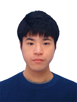 A portrait of a man in a blue sweater with short black hair, facing forward against a white background.