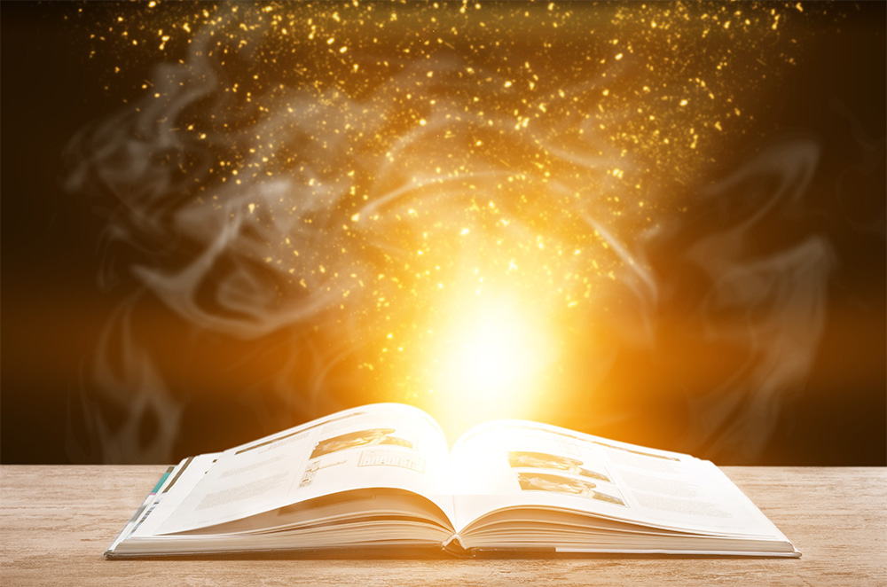 An open book on a wooden surface with a glowing, magical light and golden particles rising above it, creating an enchanting and mystical atmosphere.