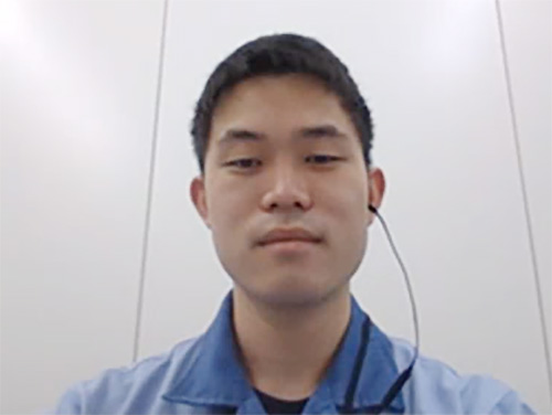 A person in a blue shirt wearing a headset, positioned against a plain light-colored background.