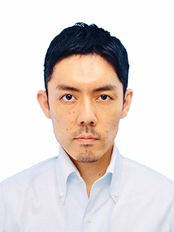 A formal headshot portrait of a man with short black hair, wearing a white shirt, looking directly at the camera against a plain background.