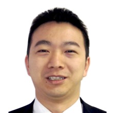 Portrait of an Asian man wearing a suit, photographed against a white background.