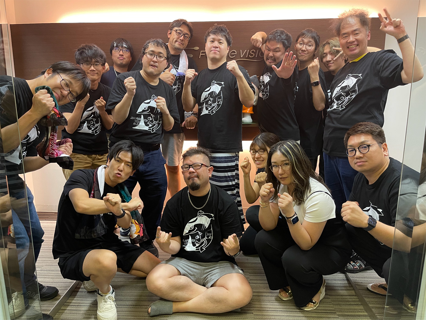 A group of people posing together, wearing matching JAWS Pankration 2024 t-shirts, making playful and energetic gestures as a team photo.