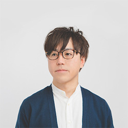 Portrait of a person with glasses and dark hair against a light background