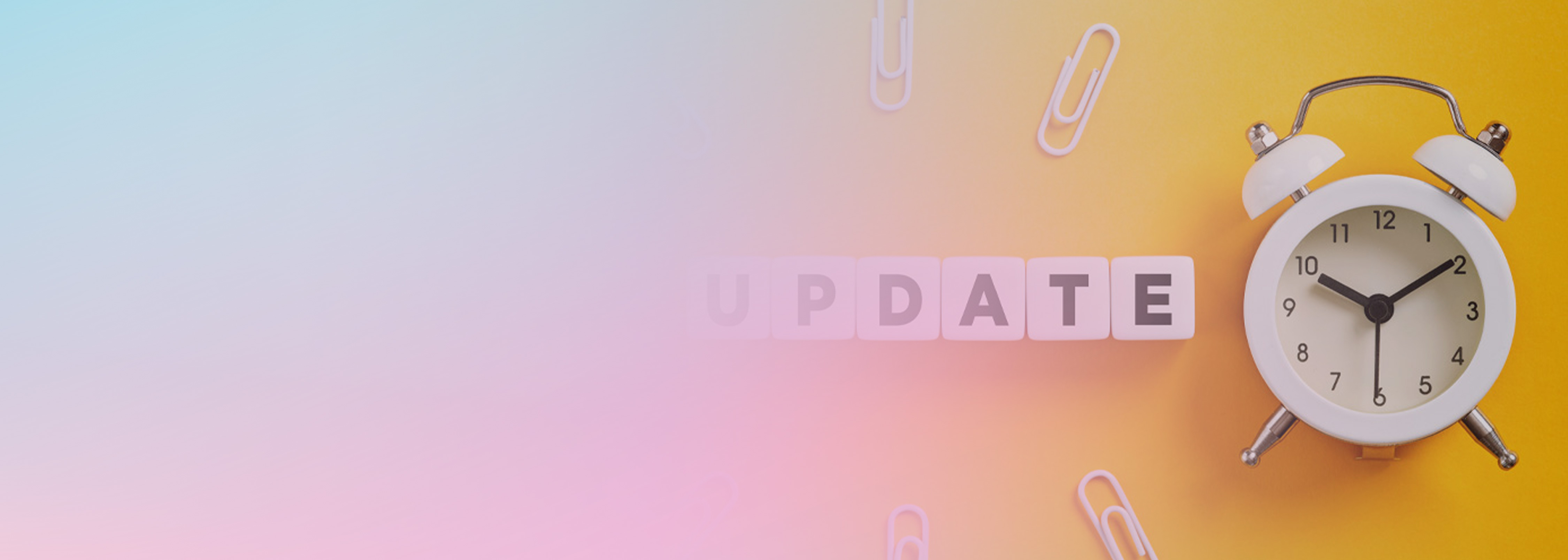 A yellow background with a white alarm clock, scattered paperclips, and blocks spelling the word 'UPDATE'. The left side of the image features a soft gradient overlay.