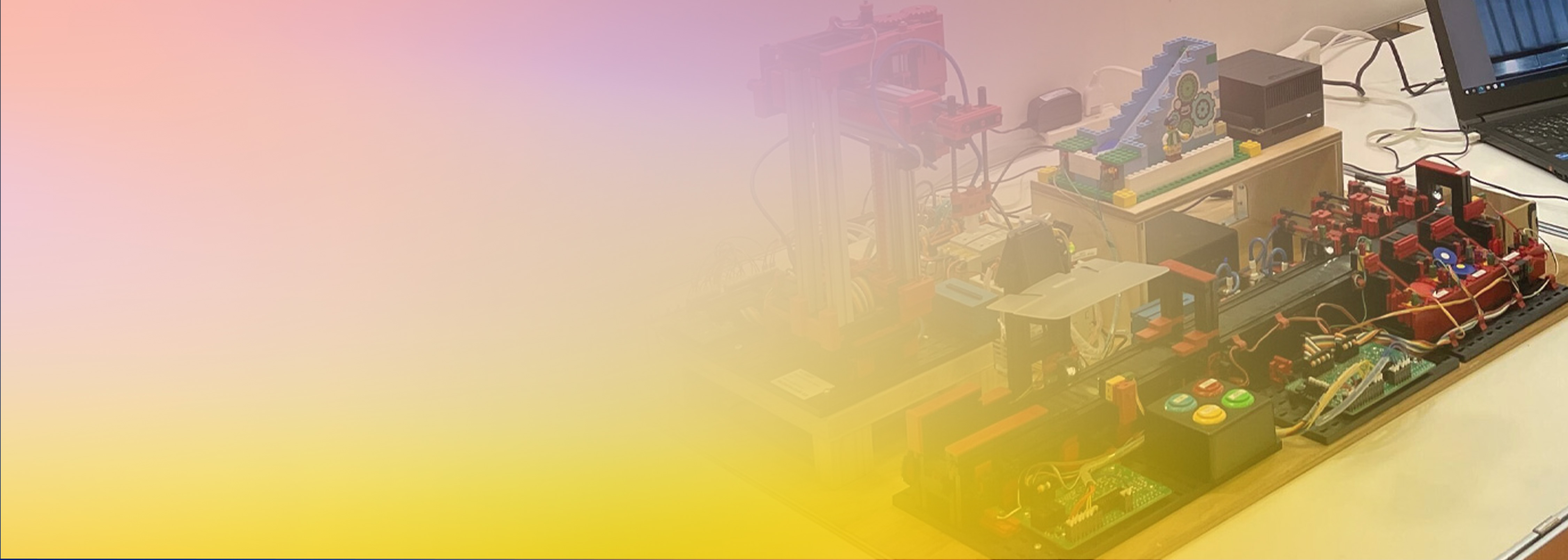 A demonstration setup of a digital twin factory using IoT and robotics, with various sensors, control systems, and a laptop, partially covered by a pastel gradient overlay.