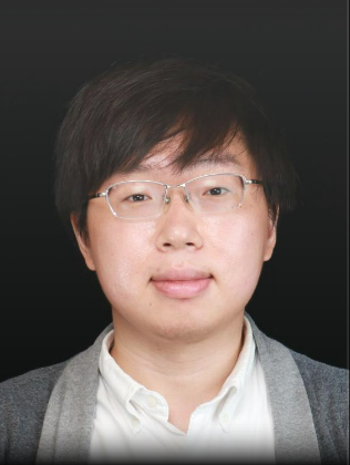 Profile photo of a person with glasses and a gray sweater, against a dark background