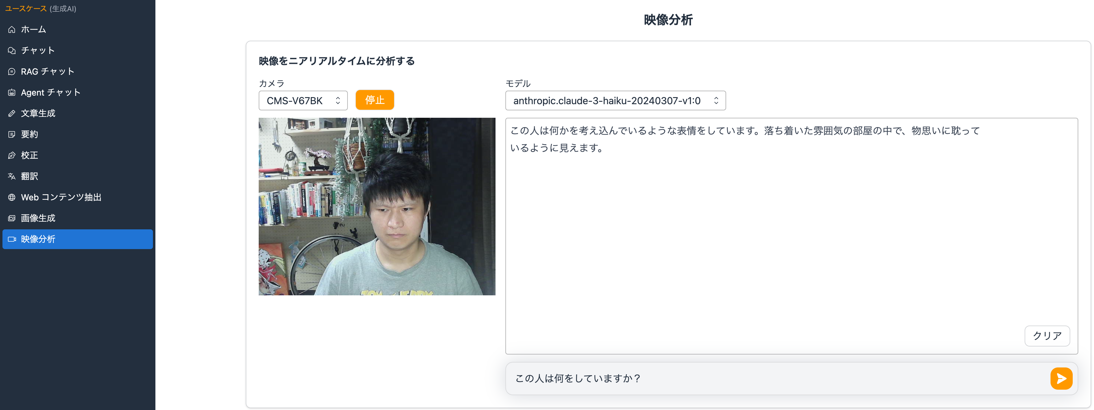 映像分析AIの操作画面が表示されたデスクトップ画面。左側にメニュー、中央にはカメラで撮影した室内に座る人物が映し出されている。人物は真剣な表情で何かを考えている様子。