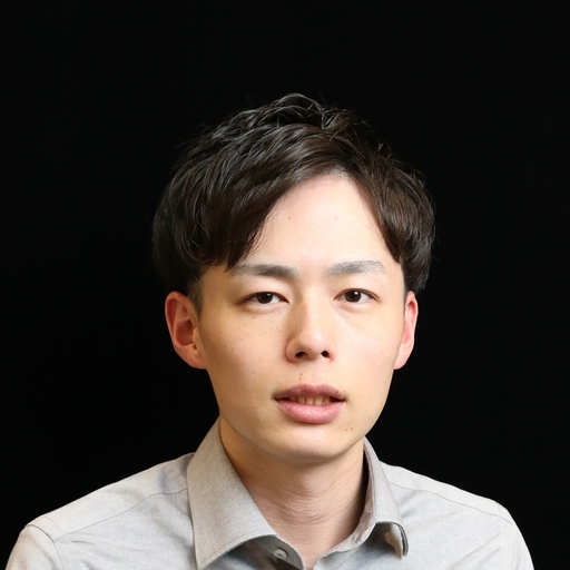 Portrait of a young Asian man in a light shirt against a solid black background.