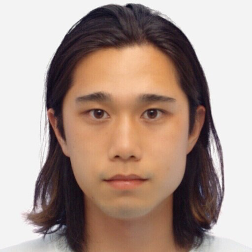 A front-facing portrait of a young man with long hair and a neutral expression against a plain background.