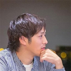 A man wearing a striped shirt is shown in profile with his hand on his chin, appearing to be deep in thought.
