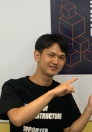 A man pointing at a poster with an AWS themed background. The poster features cube graphics commonly associated with AWS branding.